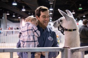 Father and child with a llama